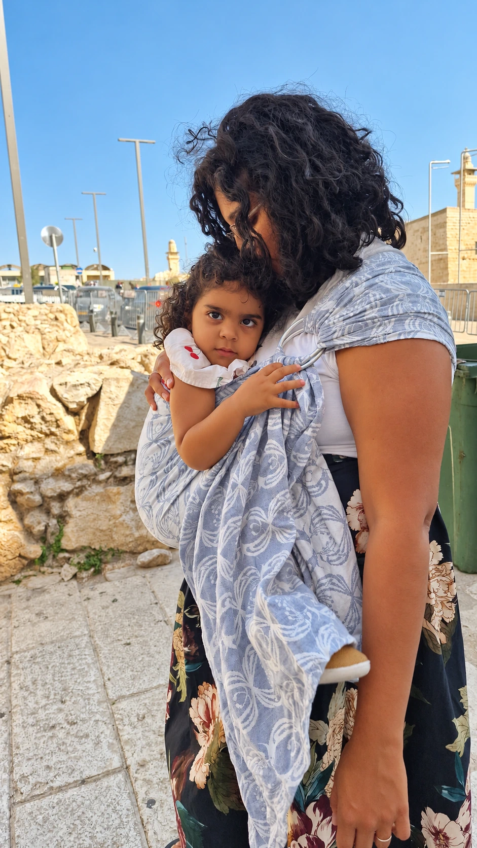 שירן נושאת פעוטה במנשא טבעות אפור